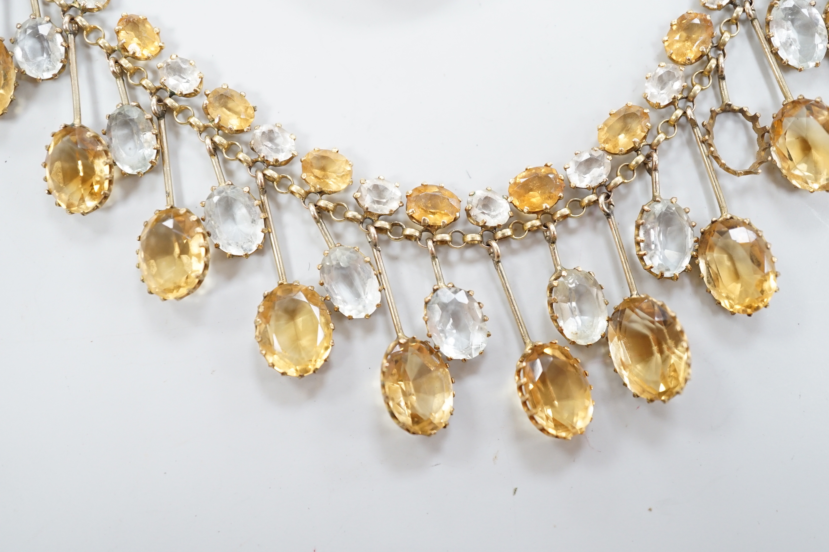 A yellow metal mounted oval cameo shell pendant, on a 9ct chain, together with a citrine and colourless beryl? set drop fringe necklace(a.f.).